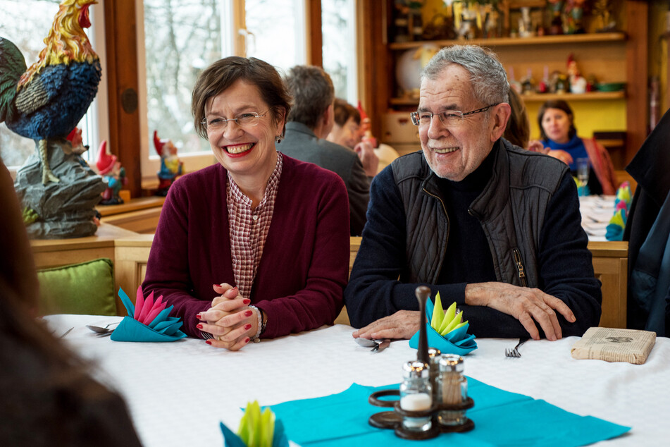 Bundespräsident von Österreich, und seine Frau Doris Schmidauer lachen bei einem Restaurantbesuch.