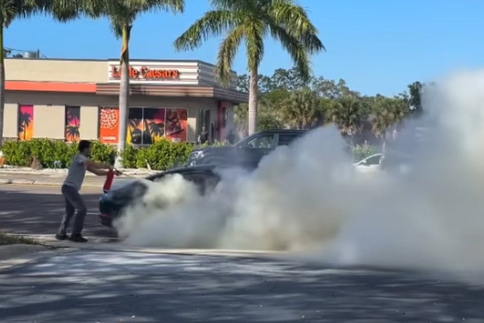 Ein weiterer Passant holt einen Feuerlöscher herbei.