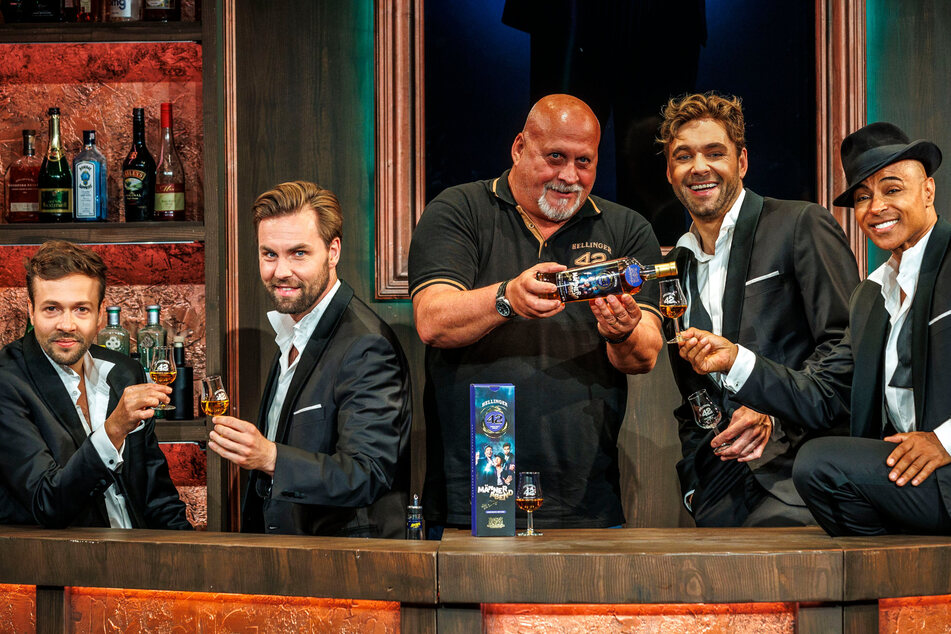 Thomas Michalski (Mitte) schenkt den Darstellern Fridjof Bundel (l.), Daniel Tille (2.v.l.), Andreas Köhler (2.v.r.) und Koffi Missah (r.) einen Whisky ein.