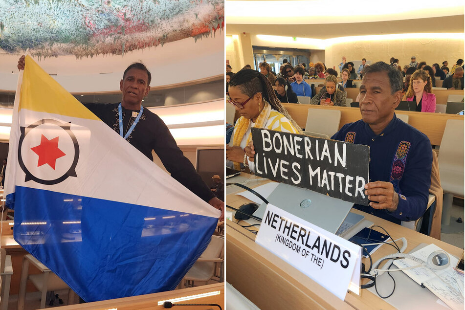 James Finies raises a flag of Bonaire and a "Bonerian Lives Matter" sign during the third session of the United Nations Permanent Forum on People of African Descent in Geneva, Switzerland.