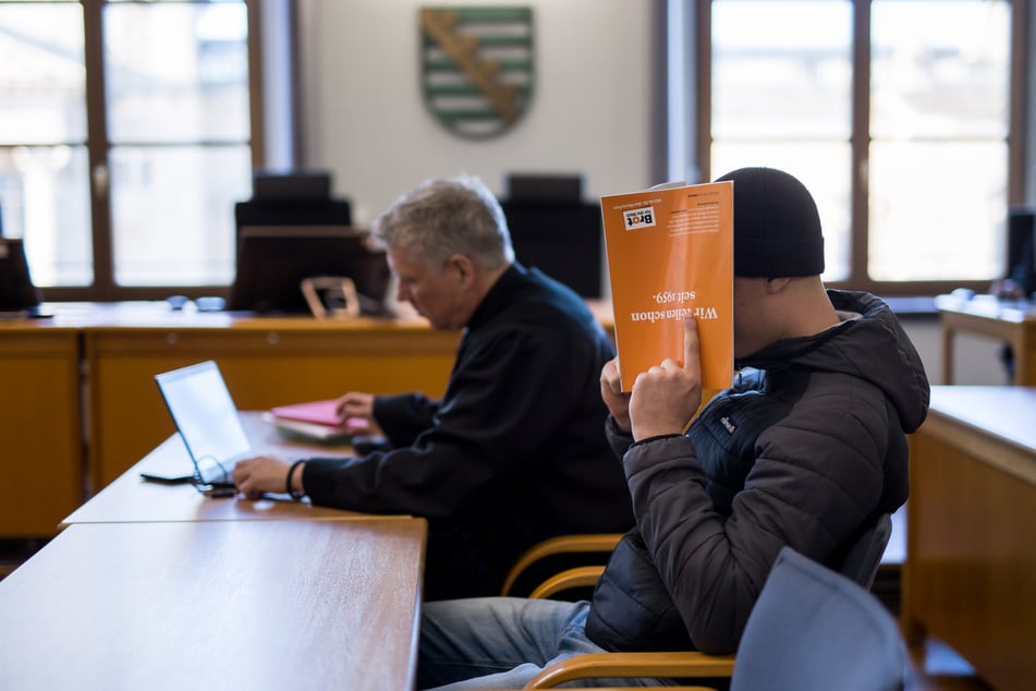 Beanie auf dem Kopf, Broschüre dicht vor der Nase - Lok-Hooligan Louis W. wollte auf der Anklagebank nicht gesehen werden.