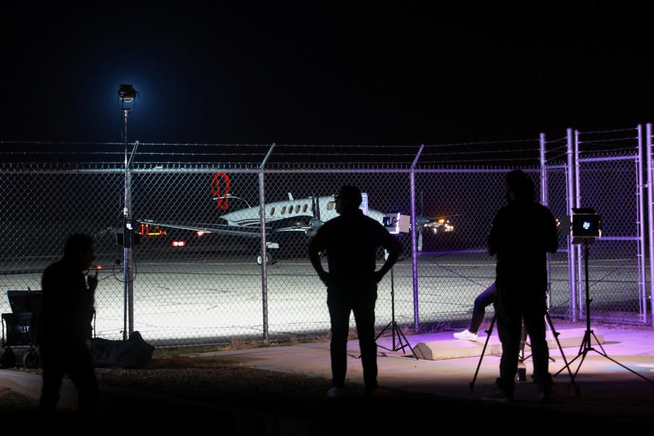 Media personnel stand at Dona Ana County private airport where a plane believed to have carried Mexican drug lord Ismael "El Mayo" Zambada and Joaquin Guzman Lopez, who were arrested in El Paso, Texas, is seen on the tarmac.