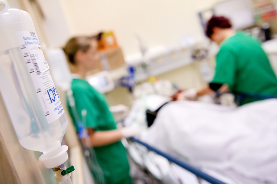 Medizinisches Personal versorgt in einem Krankenhaus einen Patienten.