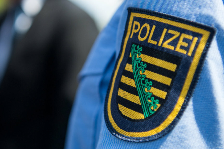 Das Logo der sächsischen Polizei ist an einer Polizeiuniform angebracht. (Symbolbild)