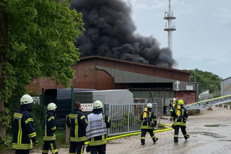 Aus der Lagerhalle in Harsefeld steigt dunkler Rauch.