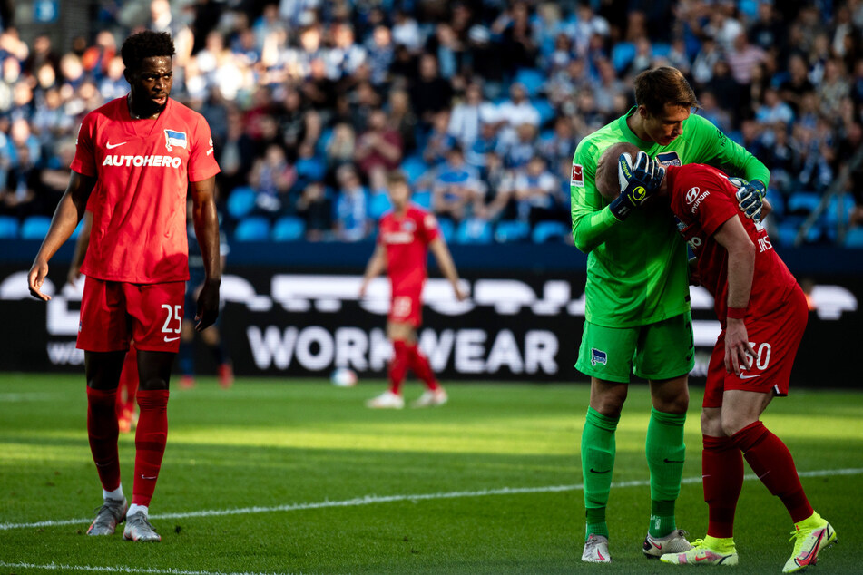 Alexander Schwolow (29/2.v.r) klatscht nach einer Klärungsaktion mit Dennis Jastrzembski (21/r.) ab. Jordan Torunarigha (24/l.) wird Hertha BSC erneut fehlen.