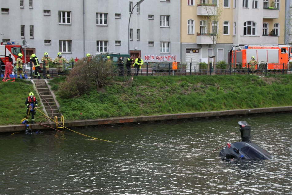 Einsatzkräfte versuchen, an das Auto im Neuköllner Schifffahrtskanal heranzukommen.