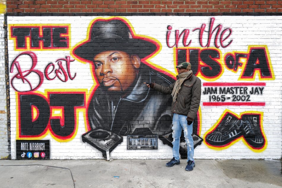 Local resident Jacob Rosthein poses before a mural paying tribute to late Run-DMC's Jam Master Jay in the Hollis neighborhood of the Queens borough of New York on January 29, 2024.
