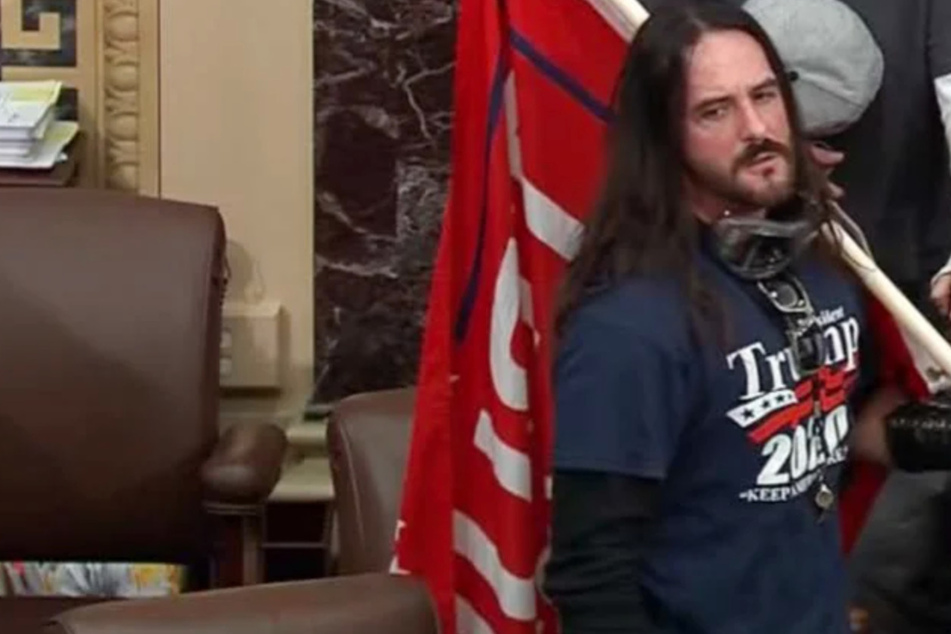 Paul Allard Hodgkins was photographed carrying a Trump flag through the Senate chamber.