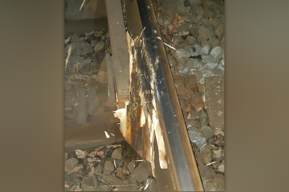 Der Holzbalken hat sich zwischen den Schienen einer Weiche verkantet.