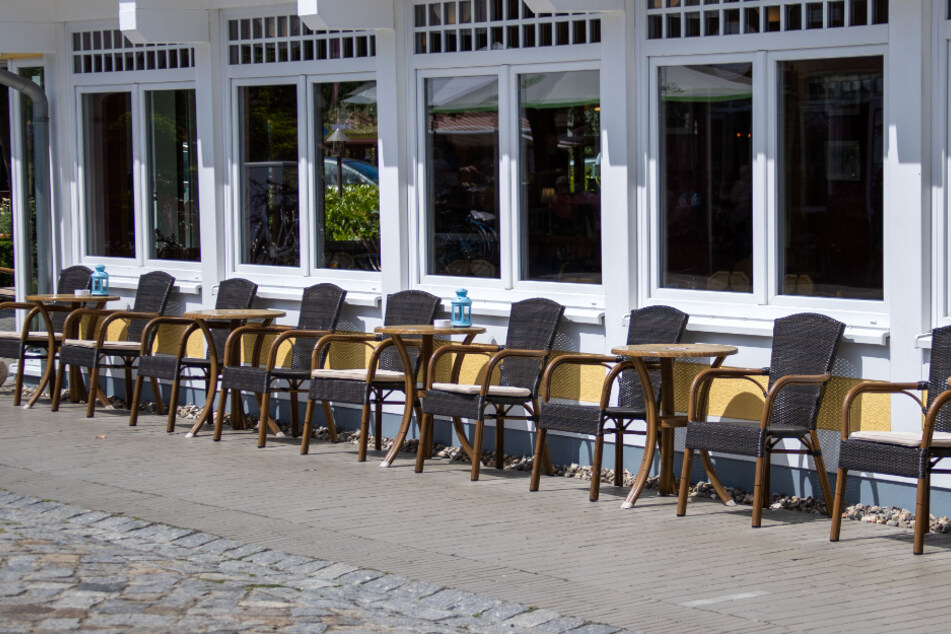Leere Stühle in den als Corona-Schutzmaßnahme vorgeschriebenen Sicherheitsabständen stehen vor einem Restaurant.