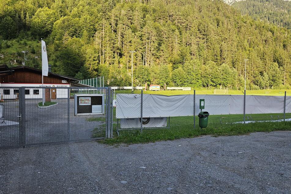 Hinter dem Gelände türmt sich ein stattlicher Wald auf.