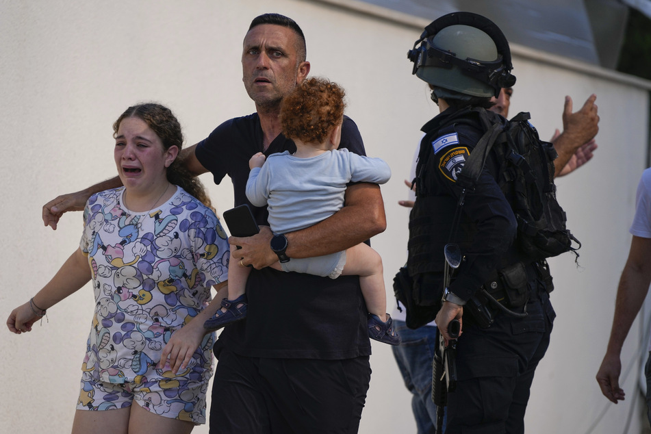 Israelische Polizisten evakuieren in Ashkelon im Süden Israels eine Familie von einem Ort, der von einer aus dem Gazastreifen abgefeuerten Rakete getroffen wurde.