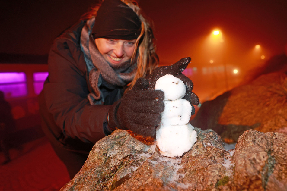 Brocken-Besucherin Tina aus Braunschweig formte aus den ersten Flocken einen Mini-Schneemann.