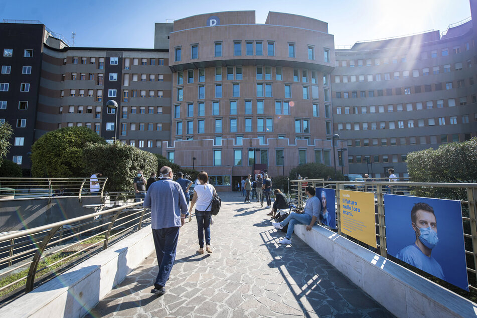 Personal, Besucher und Patienten gehen vor dem Krankenhaus San Raffaele, wo der ehemalige italienische Ministerpräsident Berlusconi ins Krankenhaus stationär aufgenommen wurde.