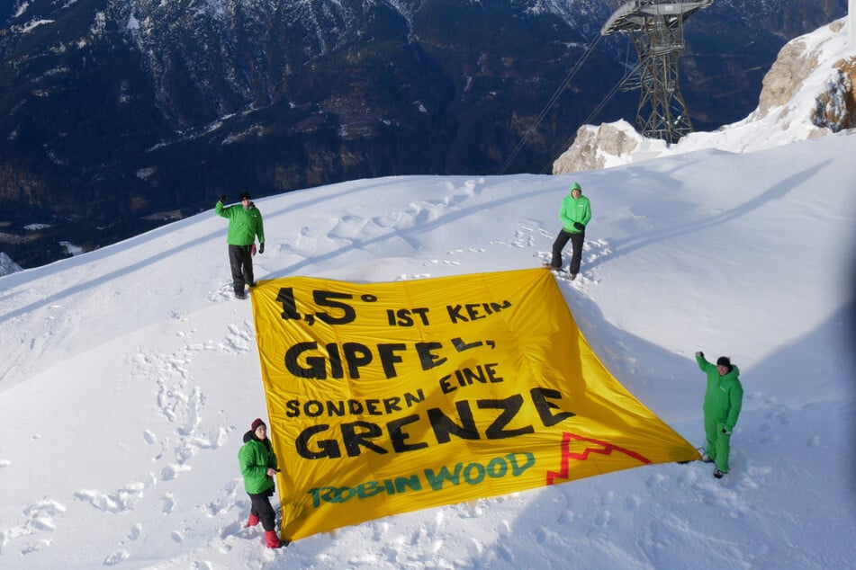 Mit einem Banner auf der Zugspitze demonstrieren Aktivisten für besseren Klimaschutz.