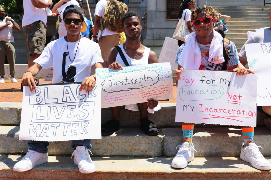 Demonstrators pose for a photo during a Juneteenth reparations rally at Newark City Hall on June 17, 2022.