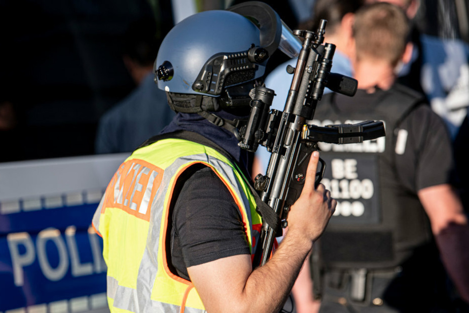 Schwer bewaffnete Polizeibeamte stehen in Berlin-Neukölln. (Symbolbild)
