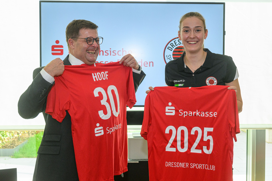 Sparkassen-Vorstand Joachim Hoof (l.) und DSC-Zuspielerin Sarah Straube zeigen Trikots mit den prägenden Zahlen 30 (Jahre Partnerschaft) und (neuer Vertrag bis) 2025.