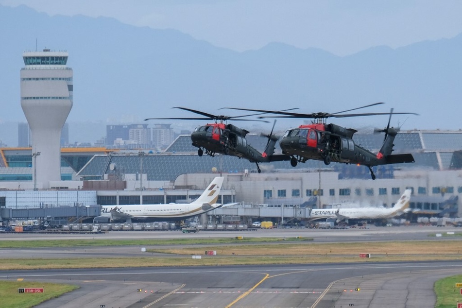 Taiwanese soldiers fly in US-made Black Hawk helicopters during the military Han Guang drill at the Taoyuan International Airport on July 26, 2023.