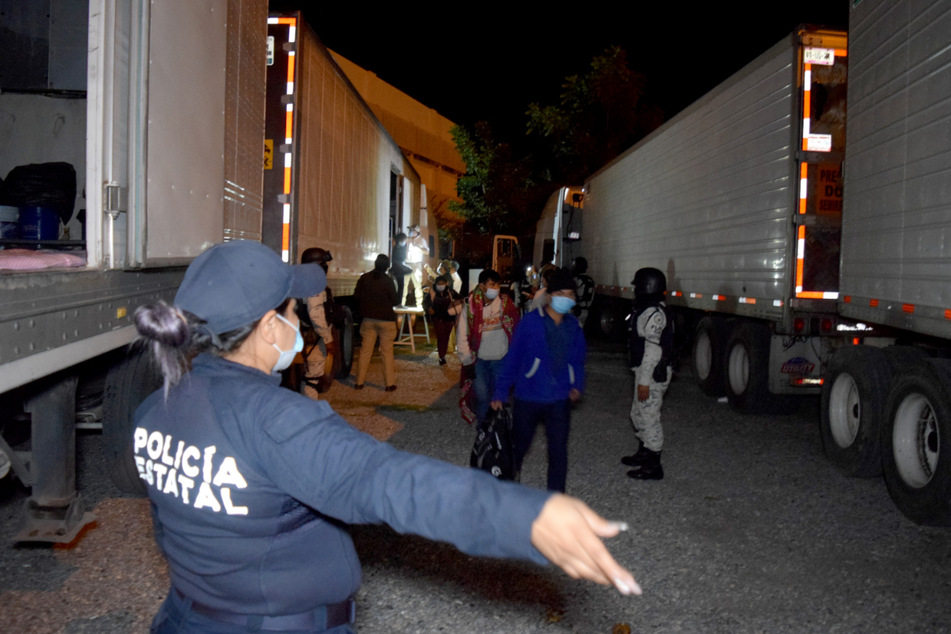 Polizisten in Hidalgo stehen zwischen Sattelzügen und weisen Migranten den Weg.