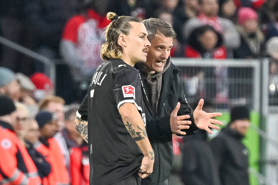 St. Paulis Trainer Alexander Blessin (52, r) gab Jackson Irvine (32) vor seiner Einwechslung noch letzte Anweisungen mit auf den Weg.