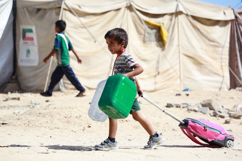 A Palestinian child drags along his bag as people flee the Hamad residential district and its surroundings in Khan Younis in the southern Gaza Strip.