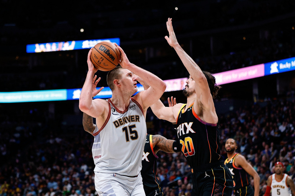 Denver Nuggets center Nikola Jokic looks to shoot against Phoenix Suns forward Dario Saric in the third quarter at Ball Arena.