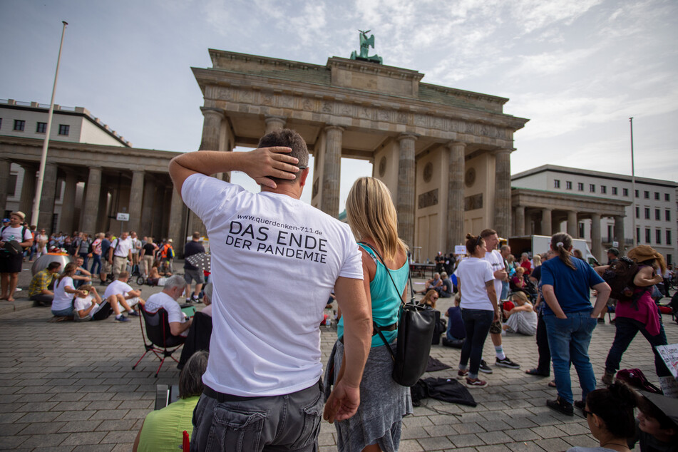 "Das Ende der Pandemie" steht am Folgetag eines Protests gegen die Corona-Maßnahmen auf dem T-Shirt eines Mannes vor dem Brandenburger Tor.