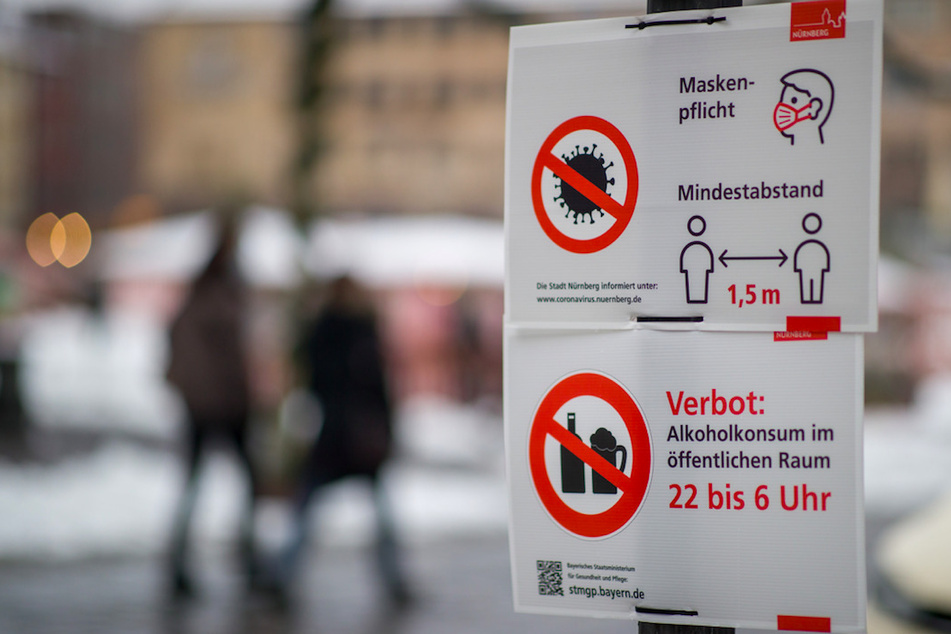 Ein Schild informiert Passanten auf dem Nürnberger Hauptmarkt über die Maskenpflicht und weitere Corona-Verhaltensregeln.