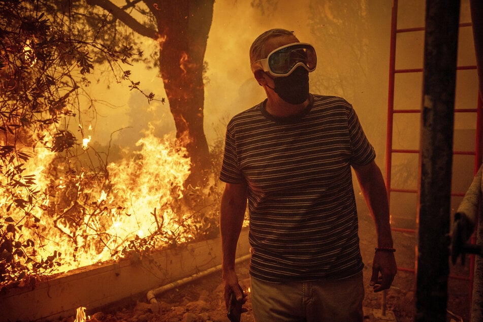 Ein Anwohner muss mit ansehen, wie sein Grundstück den Flammen zum Opfer fällt.