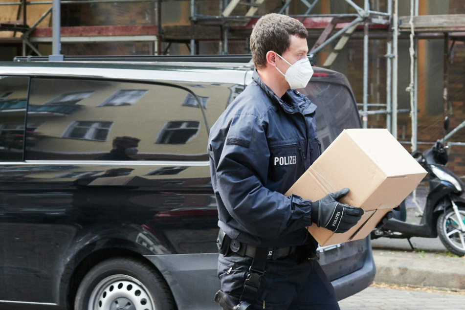 Ein Polizist trägt einen Karton, der bei einer Razzia sichergestellt wurde. Die Polizei Berlin ist am Dienstag gegen fünf mutmaßliche Menschenhändler vorgegangen. (Symbolfoto)