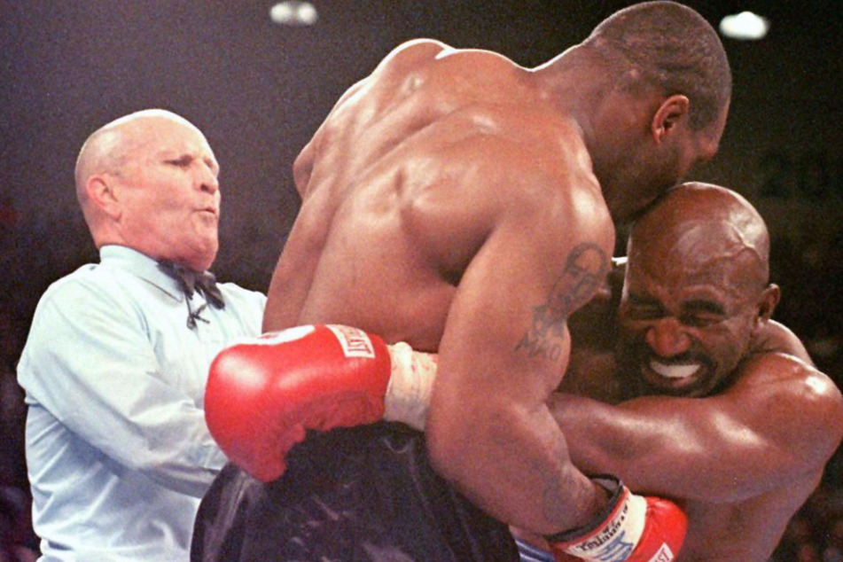 Fast 25 Jahre nach dem weltbekannten "Bite Fight" gegen Evander Holyfield (59, r.) verkauft Mike Tyson (55, M.) Süßigkeiten in Ohrenform.