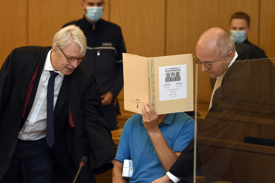 Der Angeklagte (54) und seine Anwälte warten auf den Beginn des Prozesses. Der Mann ist wegen versuchten Mordes in elf Fällen angeklagt.