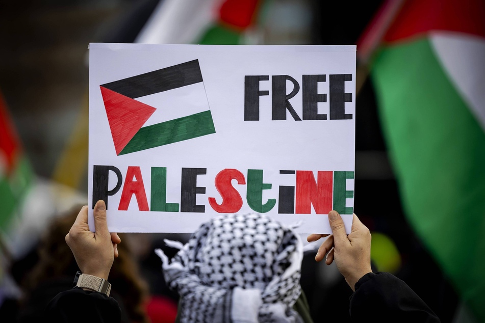 A protester raises a sign reading "Free Palestine" during a demonstration in The Hague, Netherlands, where South Africa has filed an application before the International Court of Justice accusing Israel of genocide in Gaza.