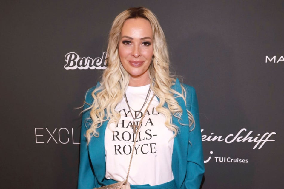 Die Ex-Frau von Ralf Schumacher strahlt nach zwischenzeitlichem Medienchaos wieder bis über beide Ohren.