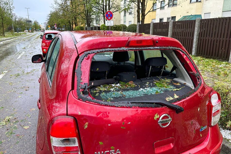 Die Heckscheibe eines Autos ist durch Hagelschlag während eines Unwetters in Augsburg zerbrochen.