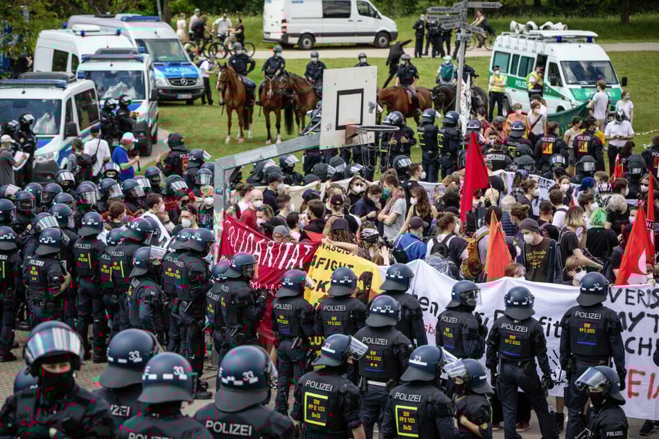 Linke Gegendemonstranten und Polizei stehen sich gegenüber.