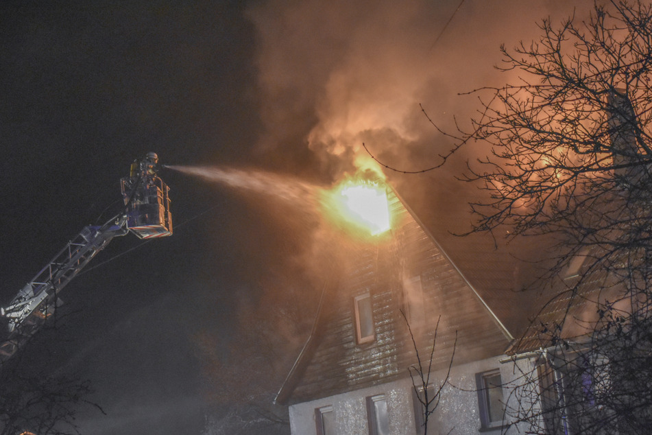 Über eine Drehleiter löschen Feuerwehrleute ein brennendes Haus. Bewohner und Tiere konnten sich rechtzeitig in Sicherheit bringen.
