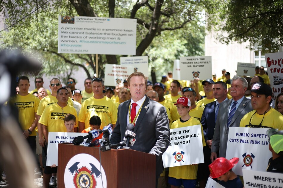 Houston Professional Fire Fighters Association President Marty Lancton (c.) speaks at a protest in favor of Prop. B.