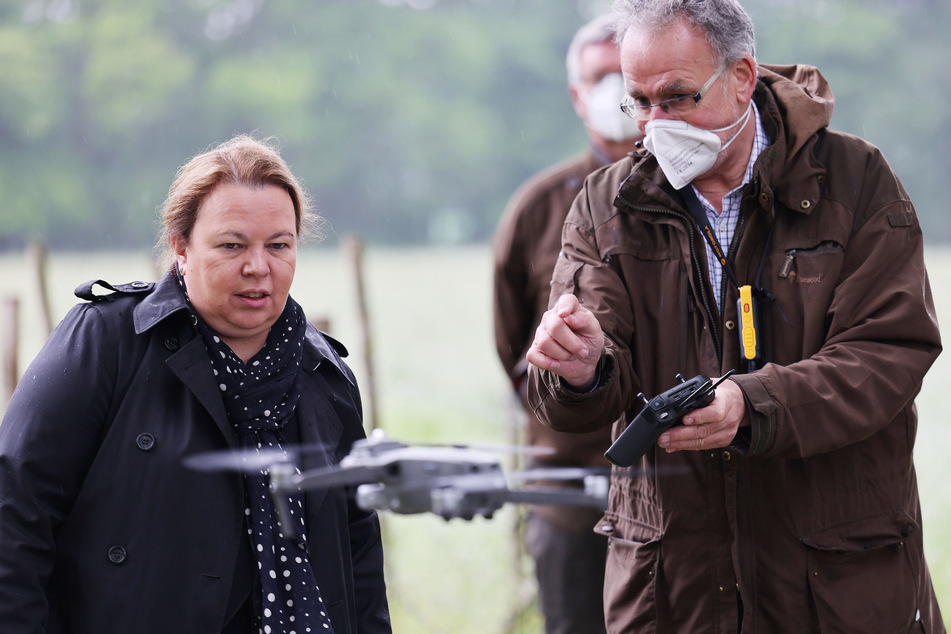 NRW-Umweltministerin Ursula Heinen-Esser (l., 55) schaut sich die Bedienung einer Drohne mit Wärmebildkamera durch einen Jäger an.