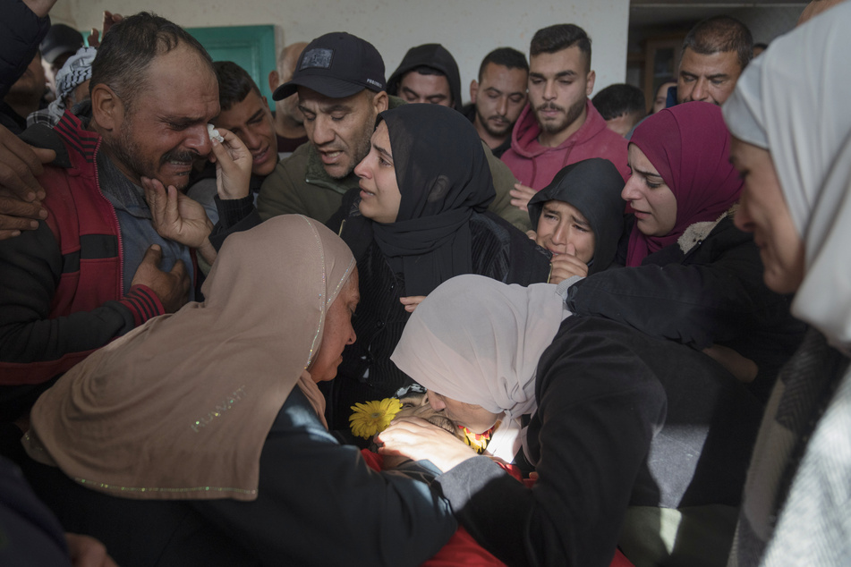 Trauernde werfen einen letzten Blick auf die Leiche eines jungen Palästinensers.