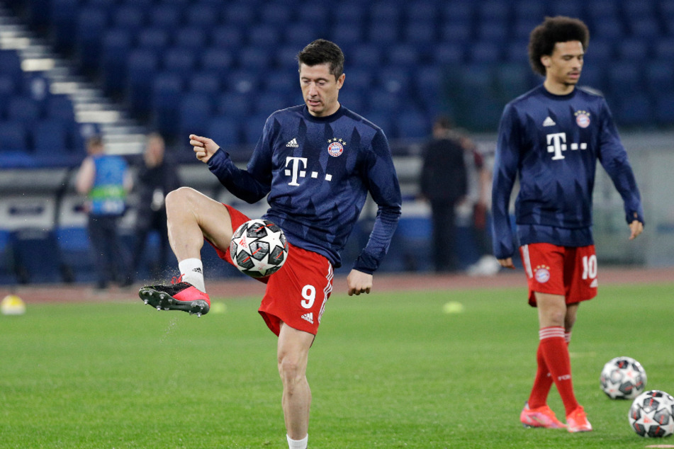 Robert Lewandowski (l.) und Leroy Sané vom FC Bayern wärmen sich vor Beginn der Partie auf.