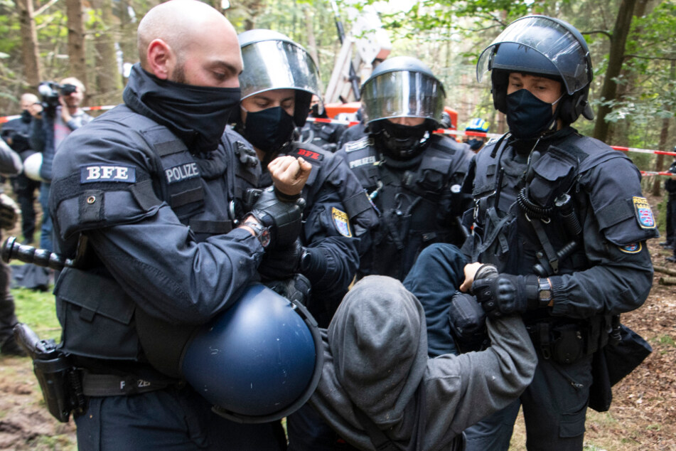 Polizisten tragen am Donnerstag einen Demonstranten weg, der versucht hatte die Polizeikette bei der Räumung zu durchbrechen.