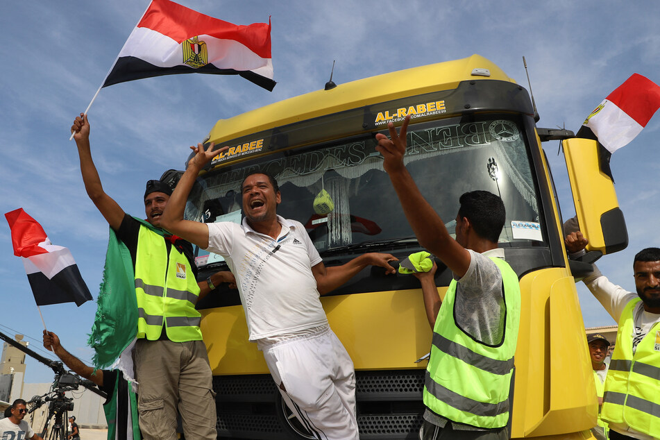 Egyptian aid workers celebrate as an aid truck crosses back into Egypt through the Rafah border crossing with the Gaza Strip on October 21, 2023.