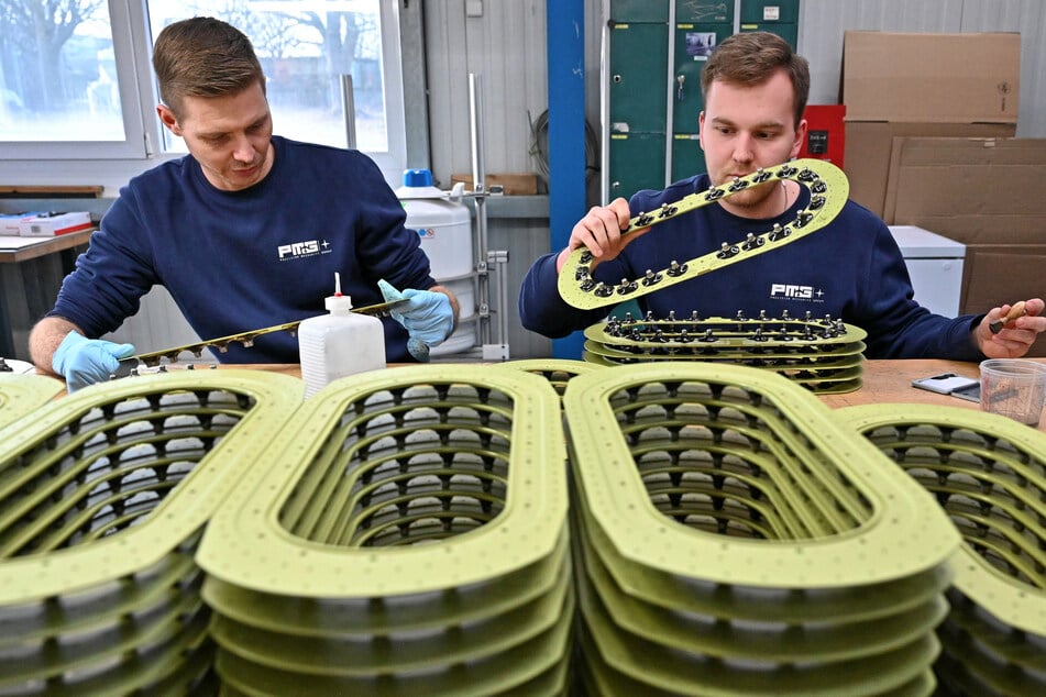 Eric (42) und Tobi (23, r.) checken Tankdeckelrahmen.