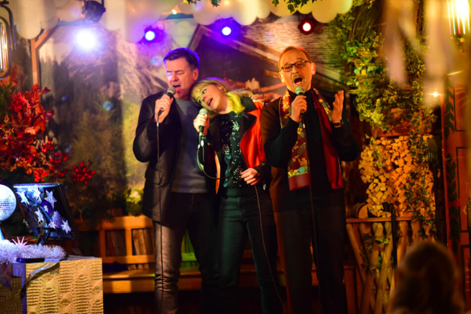 Die Kommissare Harald Neuhauser (Marcus Mittermeier, l), Angelika Flierl (Bernadette Heerwagen, M) und Ludwig Schaller (Alexander Held, r) singen Karaoke in einer Münchner Kneipe