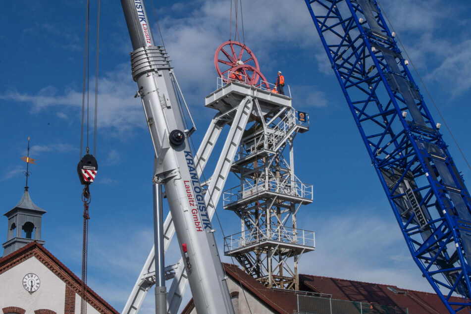 Mithilfe von zwei Kränen begann am Montag die Demontage des Fördergerüstes der Reichen Zeche. Windböen machten den Transport der 3,50 Meter im Durchmesser großen Seilscheiben kompliziert.