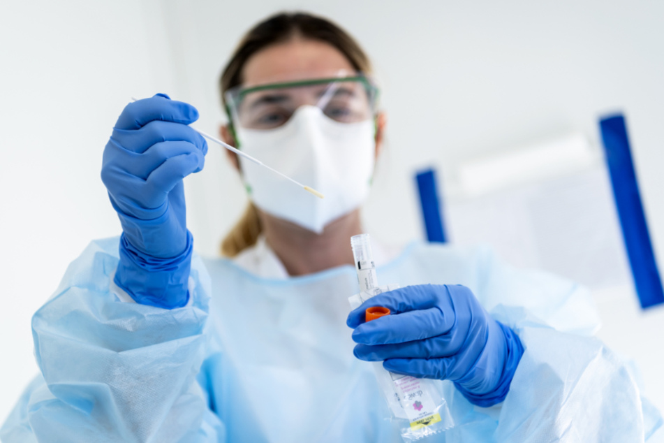 Eine Krankenschwester steckt eine Probe mit einem Nasenabstrich eines Patienten, der auf das neuartige Coronavirus getestet wird, in einen Behälter. (Symbolbild)