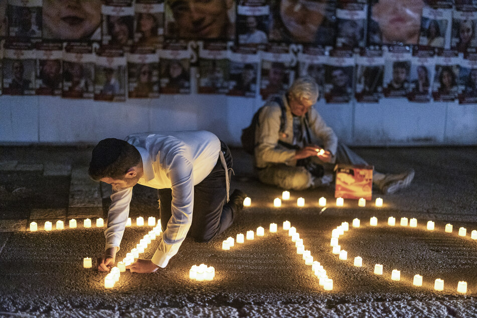 Menschen zünden während einer Mahnwache zu Ehren der Opfer des Hamas-Angriffs auf Israel am 7. Oktober Kerzen an.